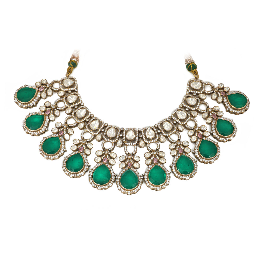 Emerald Crescent Collar: crescent-shaped necklace with green oval stones framed by clear accents