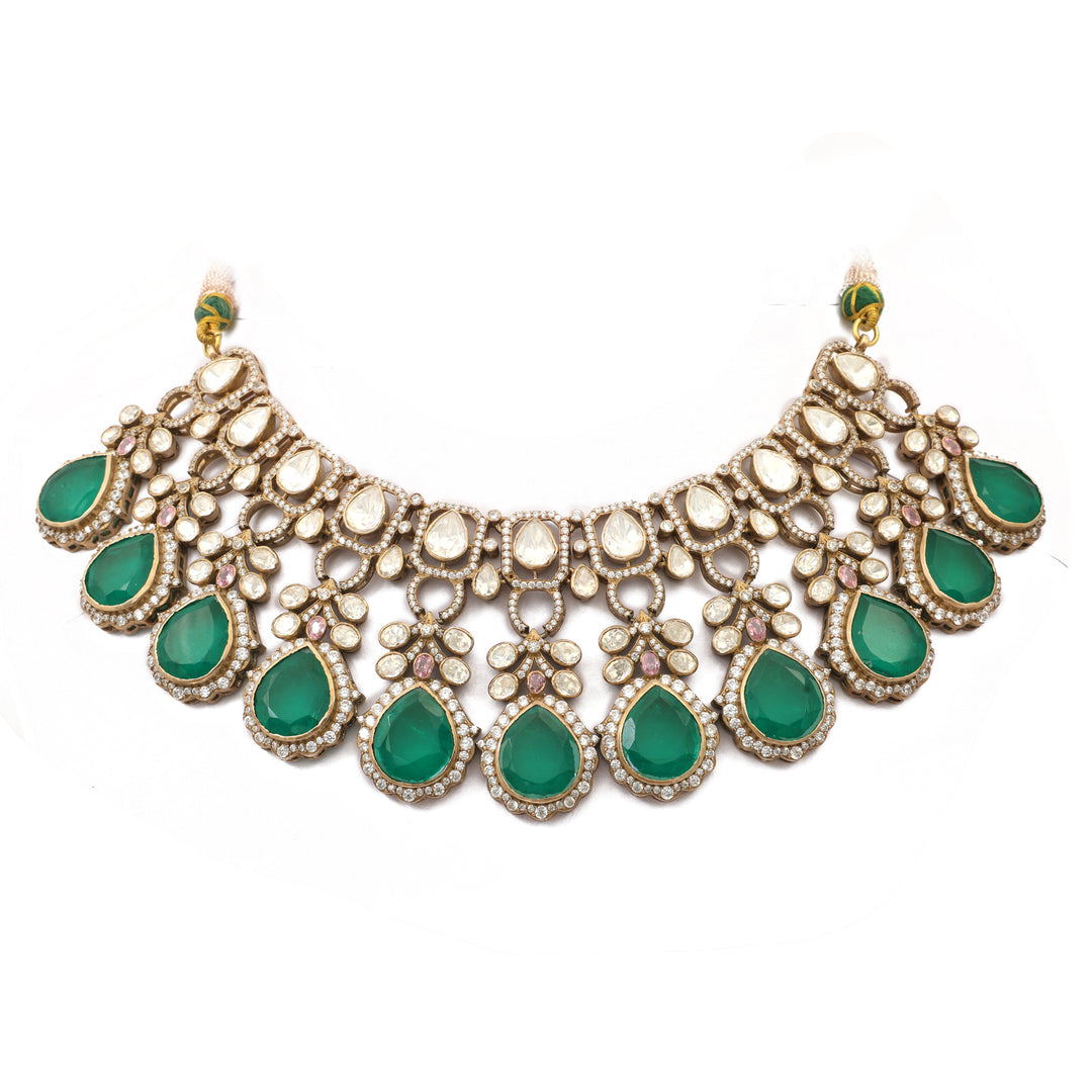 Emerald Crescent Collar: crescent-shaped necklace with green oval stones framed by clear accents