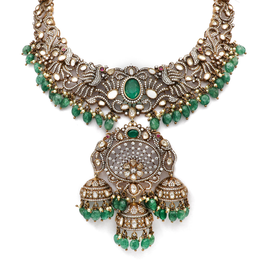 Emerald Jhumka Necklace: ornate necklace with green centre accents and a large traditional hanging pendant